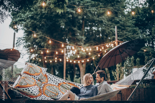 Sensual couple resting on hammock at romantic resort outdoors, summer vacation in the nature concept
