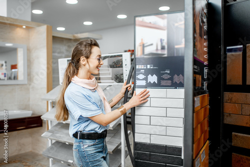 Canvastavla Young woman designer choosing ceramic tiles looking on the exposition in the sho