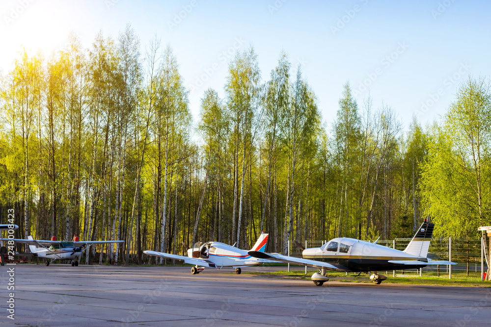 Fototapeta premium Light passenger planes parked before departure at private airport in Kronshtadt, St.Petersburg, Russia. Industrial and civil air transportation by aircraft. Professional flights on airplanes