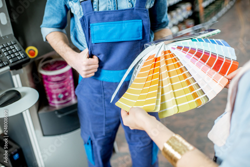 Cuadro en lienzo Choosing paint from color swatches in the building shop, close-up view