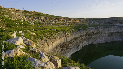 Obruk sinkhole landscape around Konya Province, Turkey. Panoramic view of karst lake in Asia. Reflection of a crater lake. a cavity ground, especially in limestone bedrock, caused by water erosion.