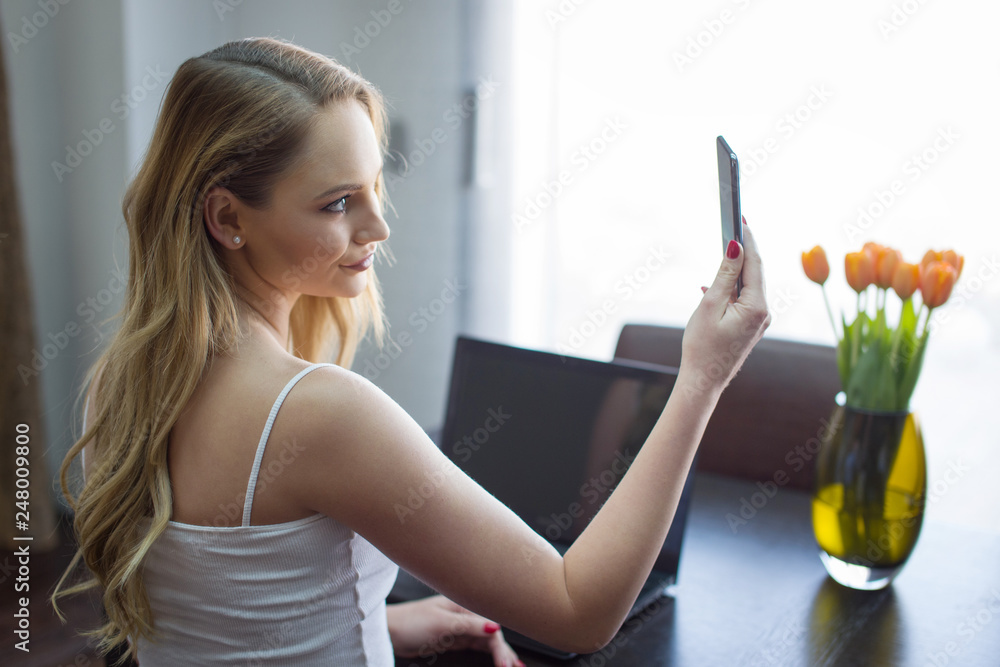 Young woman video calling on smartphone at home Young woman video calling on smartphone at home