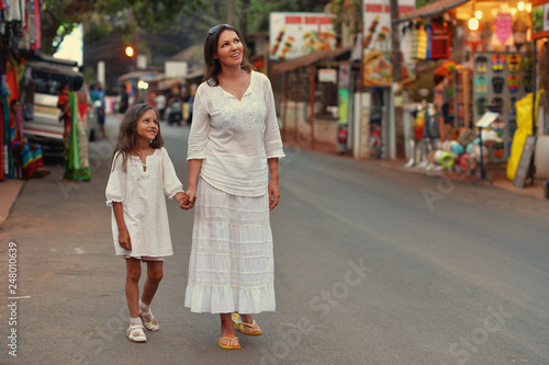 Portrait of mother and daughter walking on road