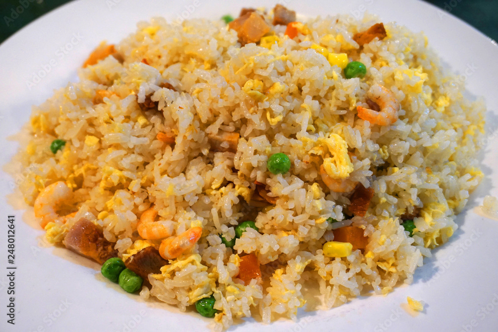Stir fried rice with beans carrot shrimp pork egg sausage onion beef chillies on white plate Vietnamese traditional food Asian cuisine Stir fried rice with beans carrot shrimp pork egg sausage onion beef chillies on white plate Vietnamese traditional food Asian cuisine