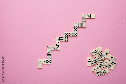 Board game dominoes on a pink background