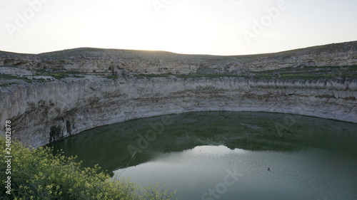 Obruk sinkhole landscape around Konya Province, Turkey. Panoramic view of karst lake in Asia. Reflection of a crater lake. a cavity ground, especially in limestone bedrock, caused by water erosion.