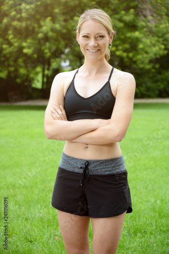Sporty woman doing sports, running and jogging outside in the park taking a break 