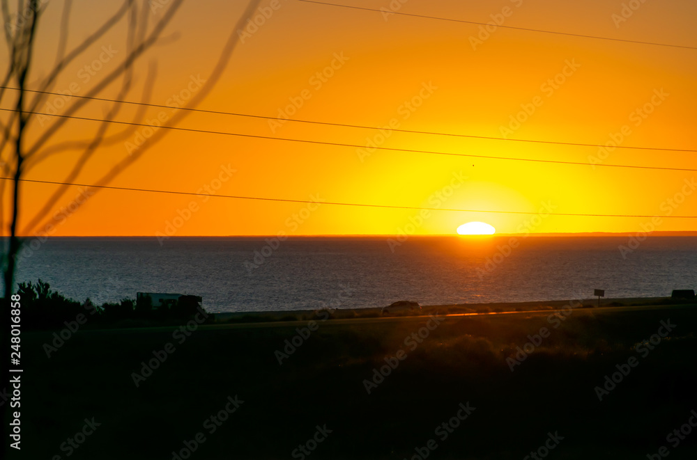 Sunset with reds, yellows, trees against light and sea, in Patagonia, Argentina. Sunset with reds, yellows, trees against light and sea, in Patagonia, Argentina.