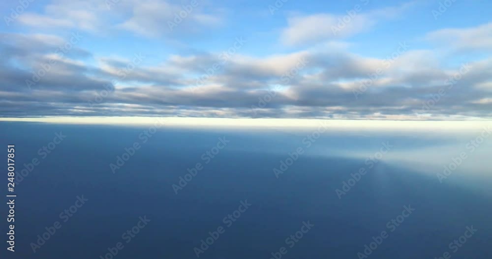 Aerial view of moving cloud and horizontal skyline. View of sky through an moving airplane's window. Aerial scenery between two layers of clouds. Aerial view of moving cloud and horizontal skyline. View of sky through an moving airplane's window. Aerial scenery between two layers of clouds.