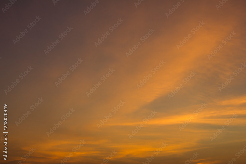 yellow orange clouds in a pink blue sunset sky