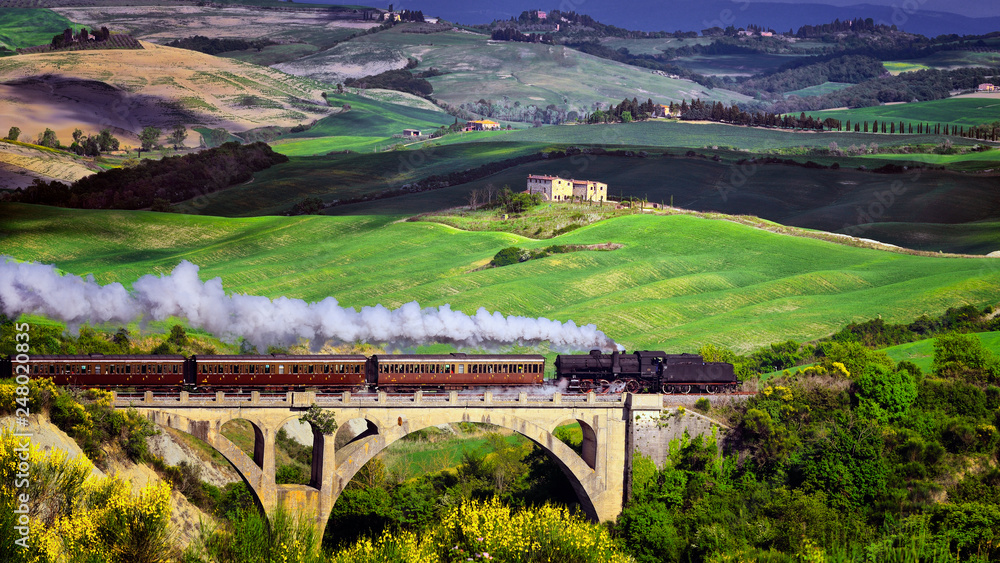 Old steam train crossing over the viaduct in Tuscany , Italy 