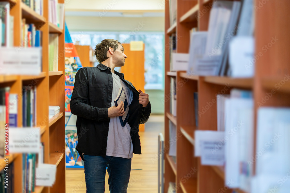 Εκτύπωση καμβά young man trying to steal book from the library. kleptomania b