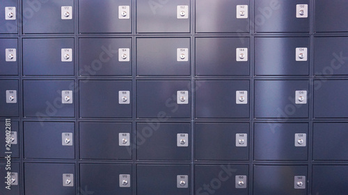 Metallic modern mailboxes lockers in gray-blue colors in a row at the entrance of a business center or at the entrance to a residential building