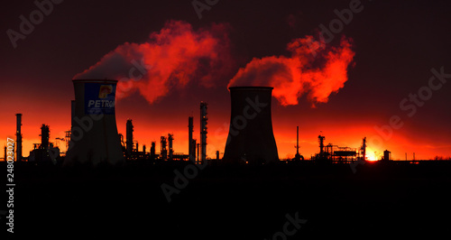 Silhouette  of power plant at sunset with red sky in Romania , Pitesti  oil refinery  photo