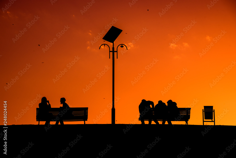 Silhouette of people having relaxing time in the park at sunset , Bucharest Romania