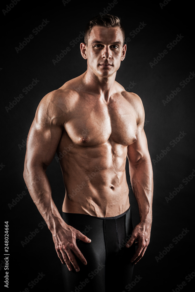 Athletic shirtless young male fitness model posing