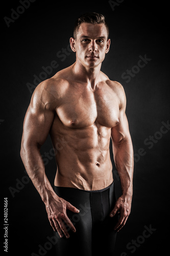 Athletic shirtless young male fitness model posing