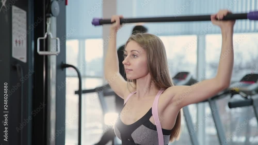 Beautiful athletic young girl exercises with gymnastic stick in the gym. Beautiful athletic young girl exercises with gymnastic stick in the gym.