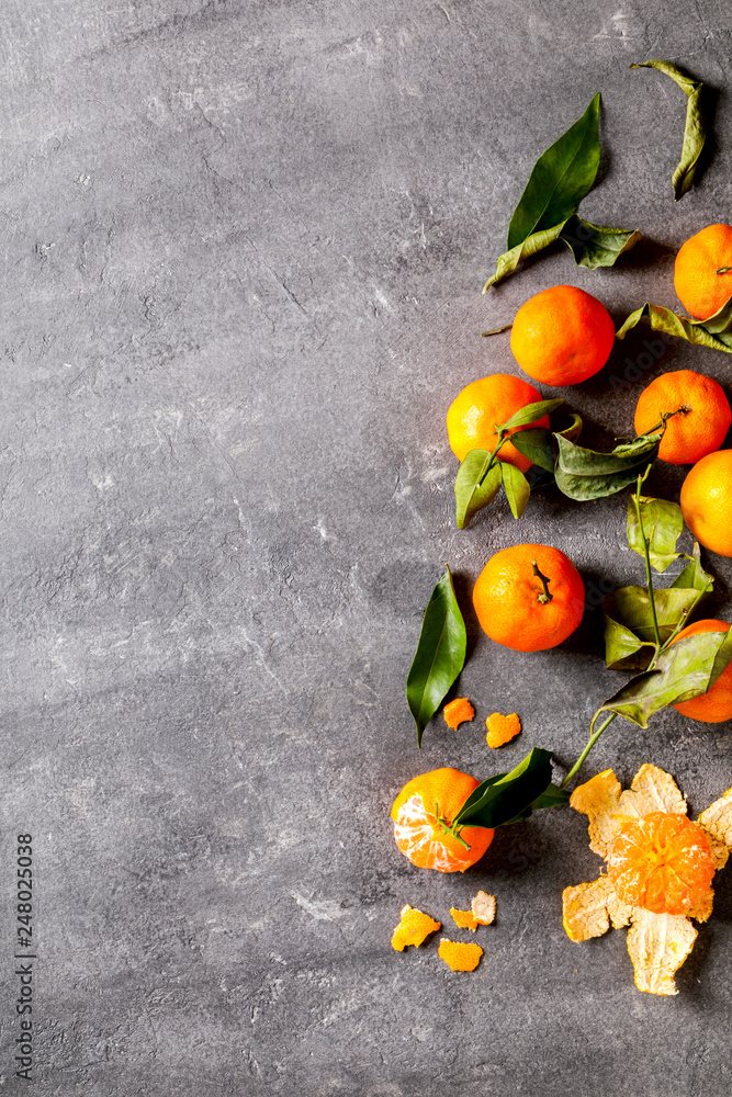 Fresh delicious mandarin, tangerine, clementine with green leaf on gray background. Ripe citrus fruits.Creative minimalistic food concept. Copy space for Text. Top View.