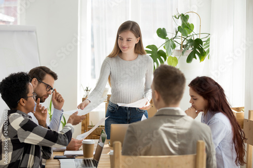 Smiling leader giving new business plan to employees at meeting