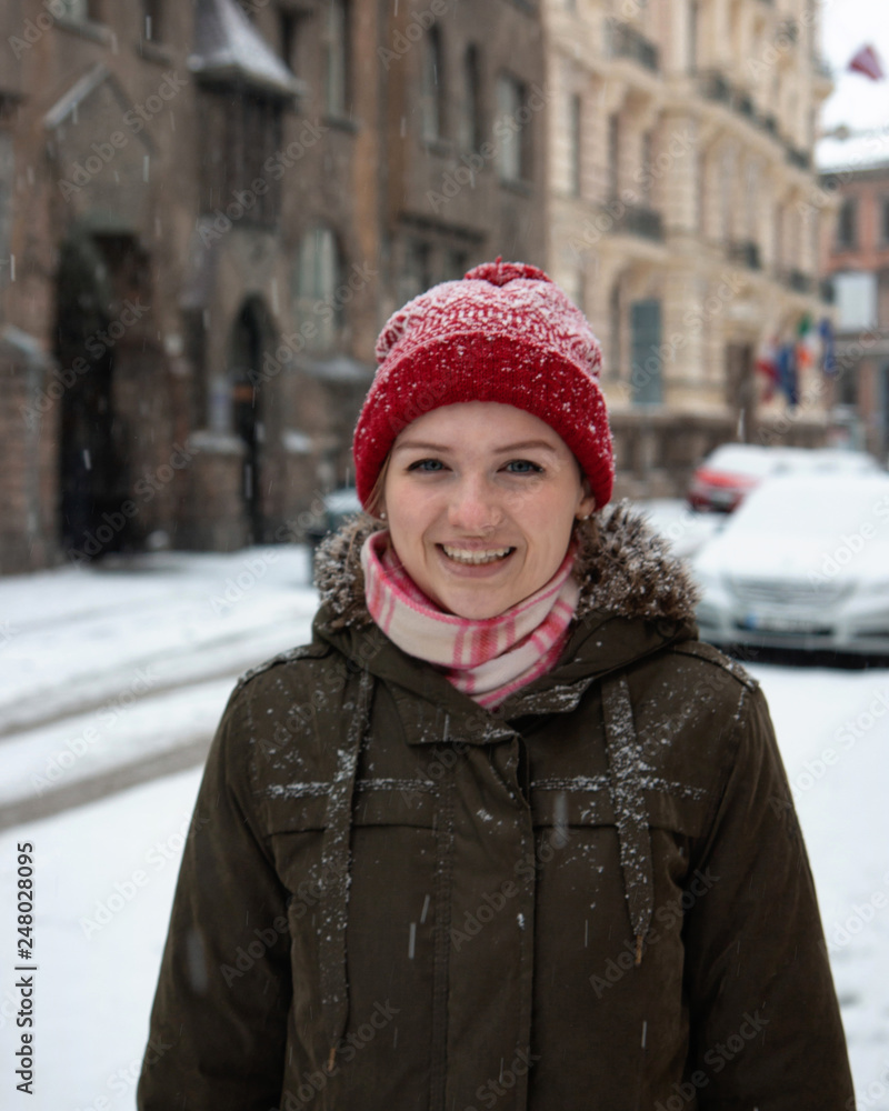 Portrait joyful young woman with blond hair having fun on street full with snow.
