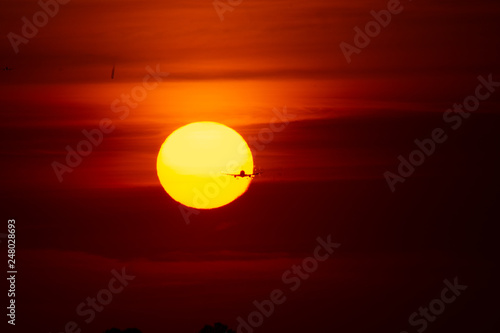 Silhouette of airplane in sunset landing on airport