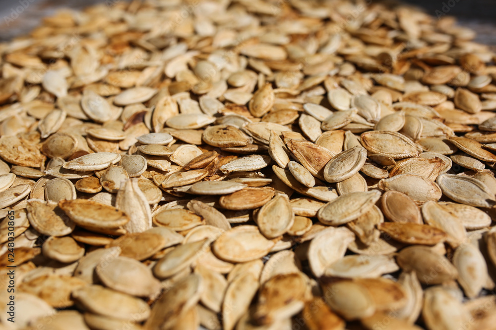 Fried pumpkin seeds lying on the old rustic background. Vegetarian superfood. Healthy diet. Natural texture background. Fried pumpkin seeds lying on the old rustic background. Vegetarian superfood. Healthy diet. Natural texture background.