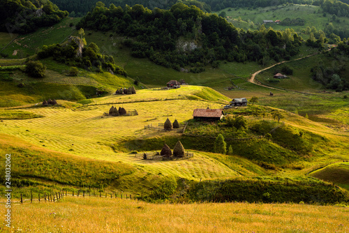 Transylvania landscape with old wood house and haystack in the misty morning in Romania 
