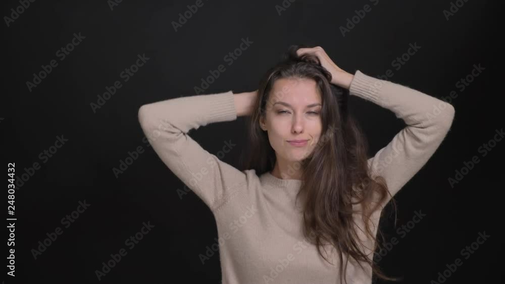 Portrait of brunette long-haired caucasian girl dancing strangely to music on black background. Portrait of brunette long-haired caucasian girl dancing strangely to music on black background.