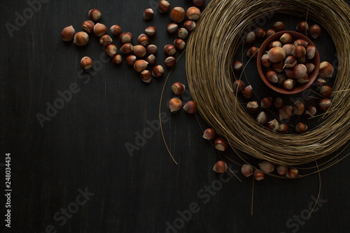 hazelnut nuts in a round bezel of hay on a black background