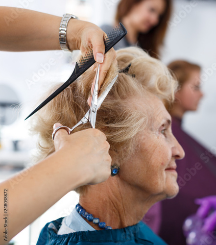 Closeup of senior woman getting haircut