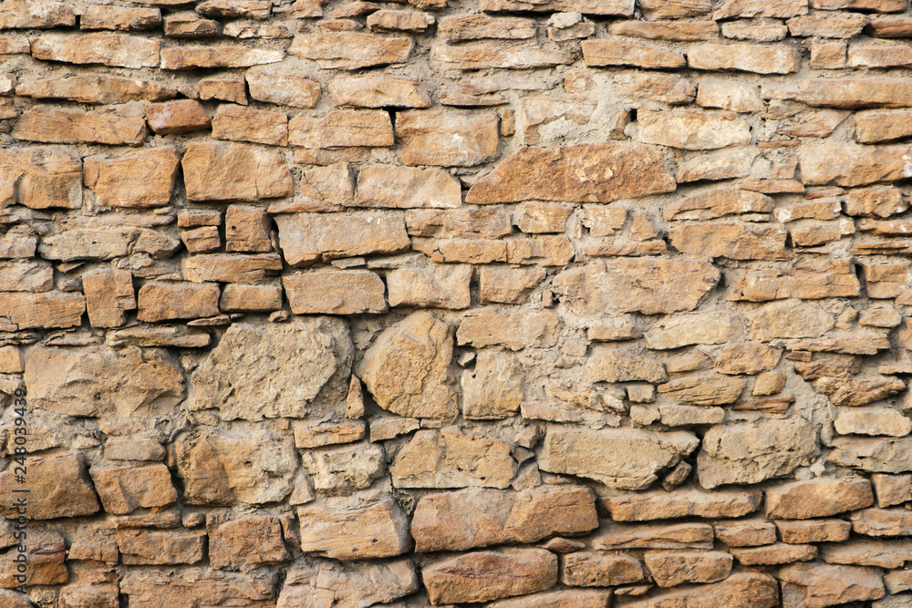 The texture of the wall of the old and dilapidated stones. Background.