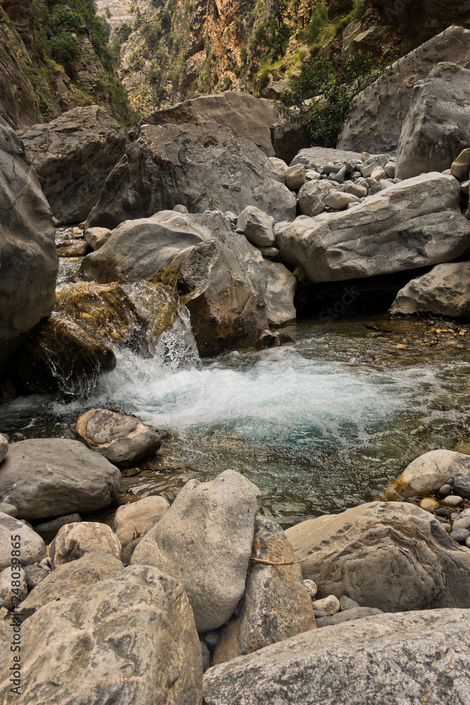 Crystal clear water of a cold mountain creek at rocky terrain of Samaria gorge, south west part of Crete island, Greece Crystal clear water of a cold mountain creek at rocky terrain of Samaria gorge, south west part of Crete island, Greece
