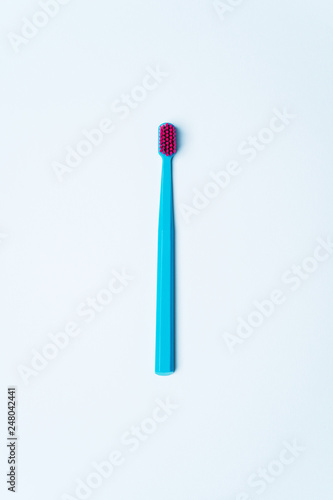 Colorful tooth brushes with bright color bristles on a light pastel blue background. Dental tools with empty space for text for  your mockup.