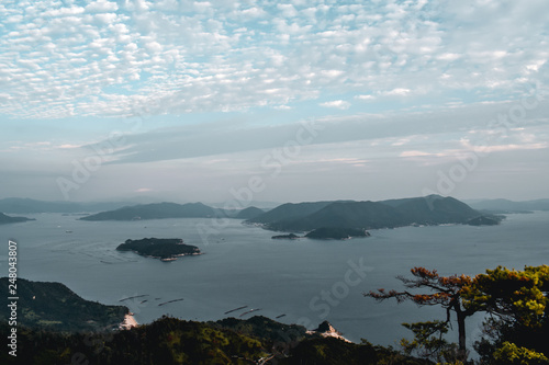 Beautiful view on trees and cloudy sky and pearl farms from Mount Misen at Miyajima island in Hiroshima Japan photo