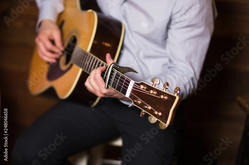 Golden Blues. Man's male hands playing the guitar , singer solo vocal woman on wooden wall background, electric or acoustic guitar with nature light. Concept of jazz boys band performing on events 