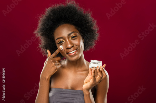 Positive nice young woman using organic cream