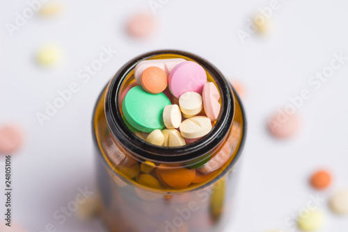 Pills, tablets in the glass bottle on a white background