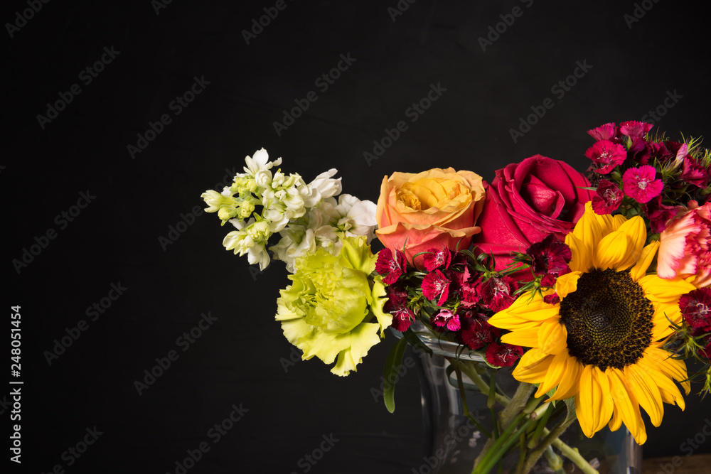 Fototapeta premium Bouquet of white yellow and red flowers in a vase on a dark background