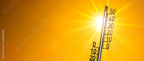 Hot summer or heat wave background, bright sun with thermometer photo