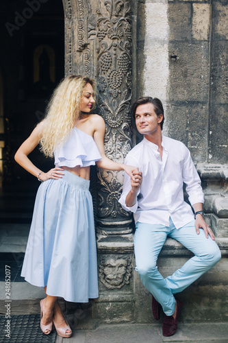 beautiful happy couple in love posing at old building in sunlight  in city street. stylish hipster groom and blonde bride embracing. romantic moments in summer city on vacation © sonyachny