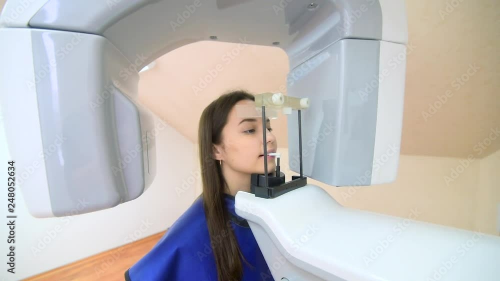 A beautiful girl is standing in a dental tomography, medical office, dentistry, patient A beautiful girl is standing in a dental tomography, medical office, dentistry, patient