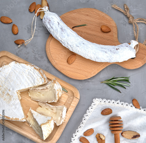 round piece of brie cheese and sausage on a wooden board