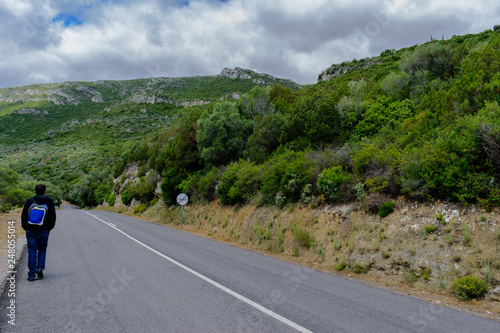 Young man walking backwards on the road in the mountains  Arr  bida Mountain Natural Park - Portugal