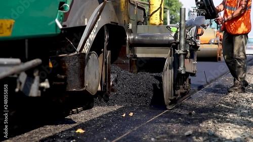 Asphalt making machine pours asphalt onto prepared road