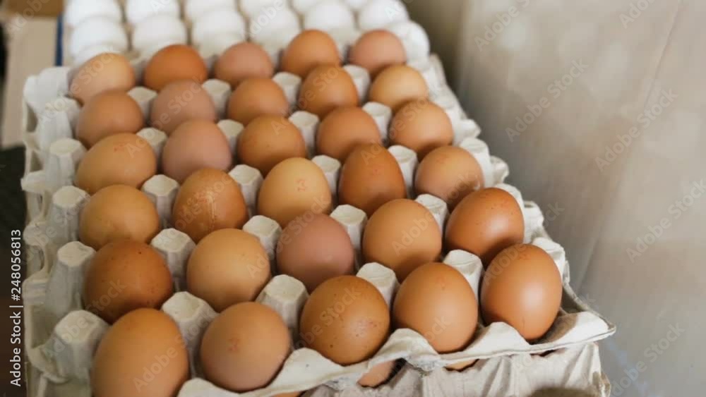 Colored eggs are in cardboard boxes. Smooth top-down movement, three-quarters of a turn, real time, natural light, indoors. Colored eggs are in cardboard boxes. Smooth top-down movement, three-quarters of a turn, real time, natural light, indoors.