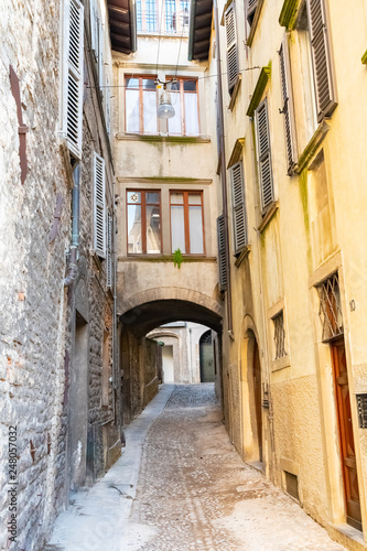 Fototapeta Naklejka Na Ścianę i Meble -  Beautiful Old narrow street of small medieval city Citta Alta, perspective of street in Bergamo, Italy