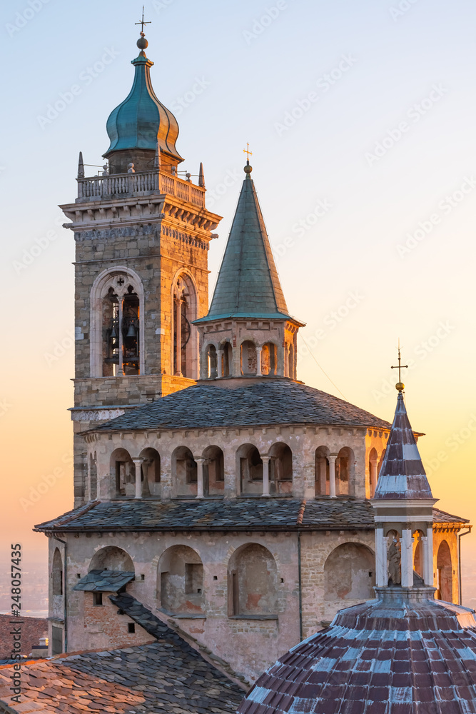 Aerial view of the Basilica of Santa Maria Maggiore and the chapel Colleoni during the sunset with Po plain in background, Citta Alta, Bergamo, Italy