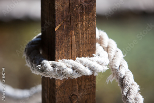 White ropes tied to wooden posts and light shines. © fotoru