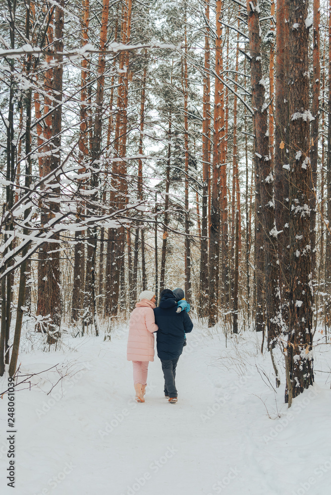 Walking family with a child. Family walks in nature in winter. Winter family walk in nature. A lot of snow.